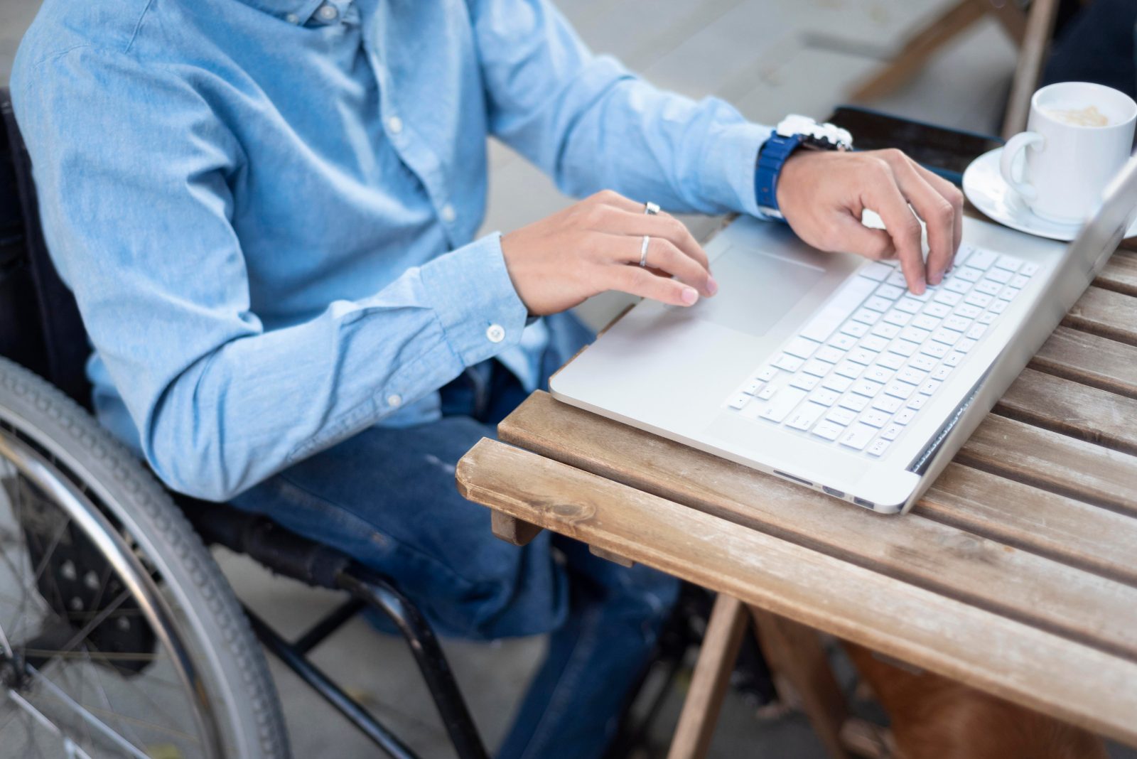 Gros plan sur les mains d’une personne en situation de handicap utilisant le clavier d’un ordinateur portable