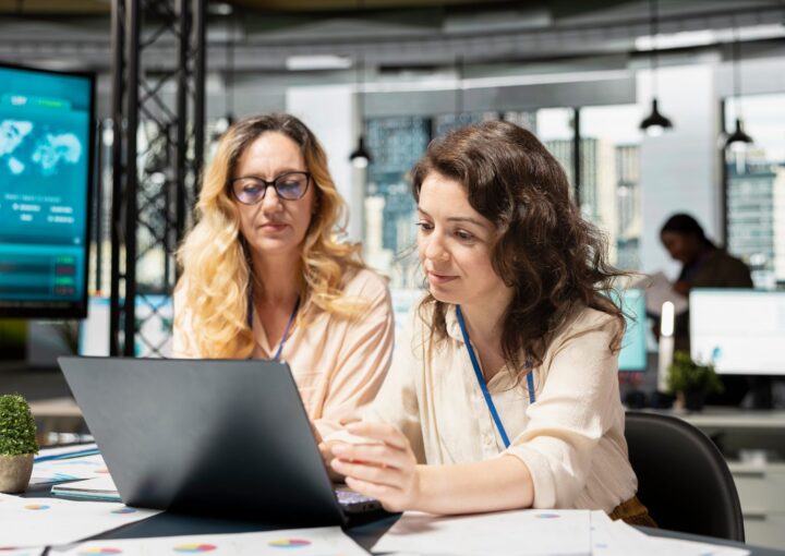 Equipe d'une PME luxembourgeoise reunie autour d'un ordinateur portable pour passer en revue le suivi de ses clients