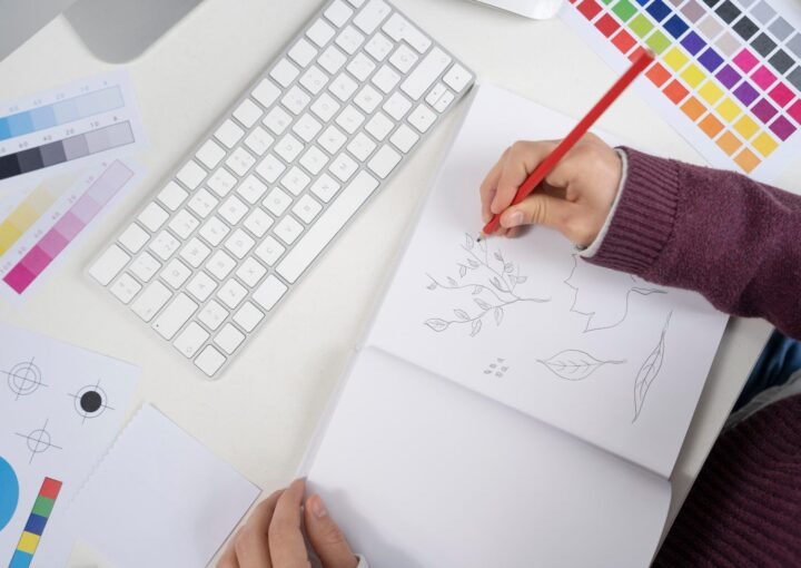 Graphiste dessinant des propositions de logo sur un carnet, illustration du budget d'une identité visuelle pour une PME au Luxembourg