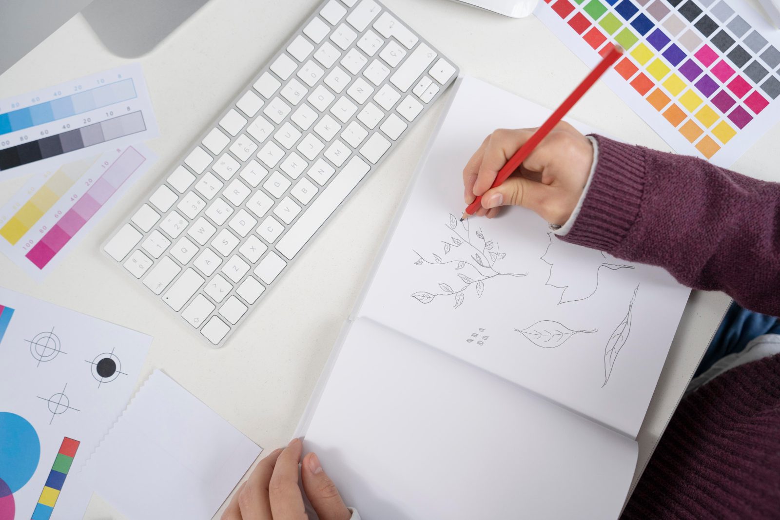 Graphiste dessinant des propositions de logo sur un carnet, illustration du budget d'une identité visuelle pour une PME au Luxembourg